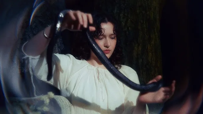 dziewczyna w białej sukience trzymająca węża